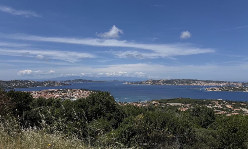 Photo showing blue water, land, islands, and sky of Sardinia.